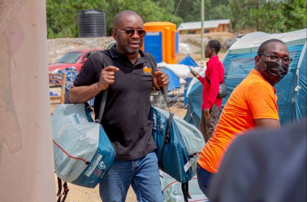 MIIF CEO carrying some of the goods donated to the Appiatse Disaster Community